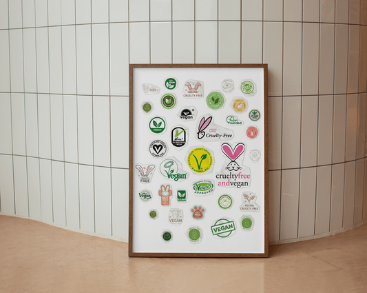 Wall art full of vegan and cruelty-free logos, leaning against white subway tiles, on a curved corner, blending modern aesthetics with ethical messaging.