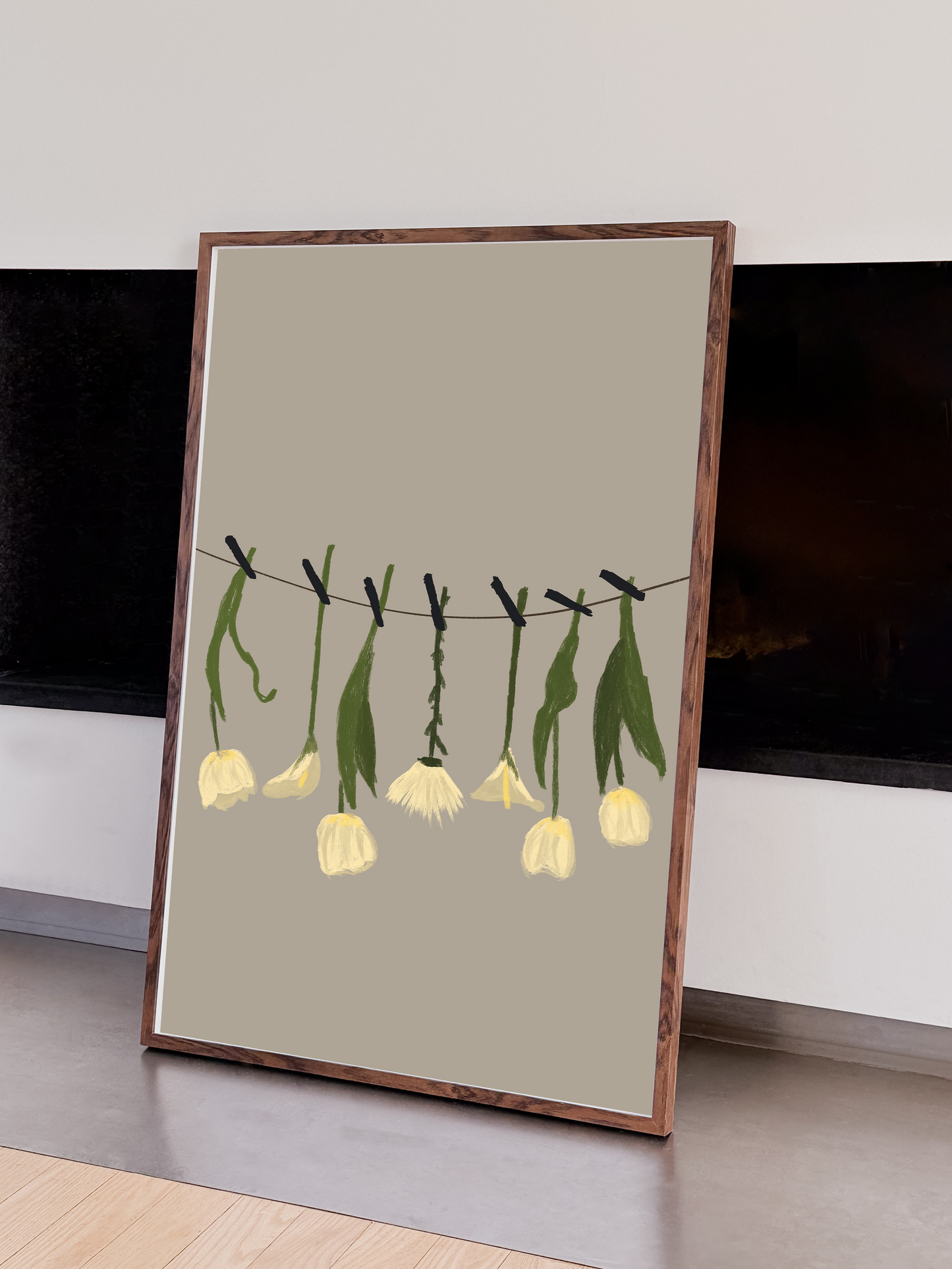 An elegant printable digital illustration of white flowers on a clothesline, in a dark wooden frame leaning against a wall near a modern fireplace.