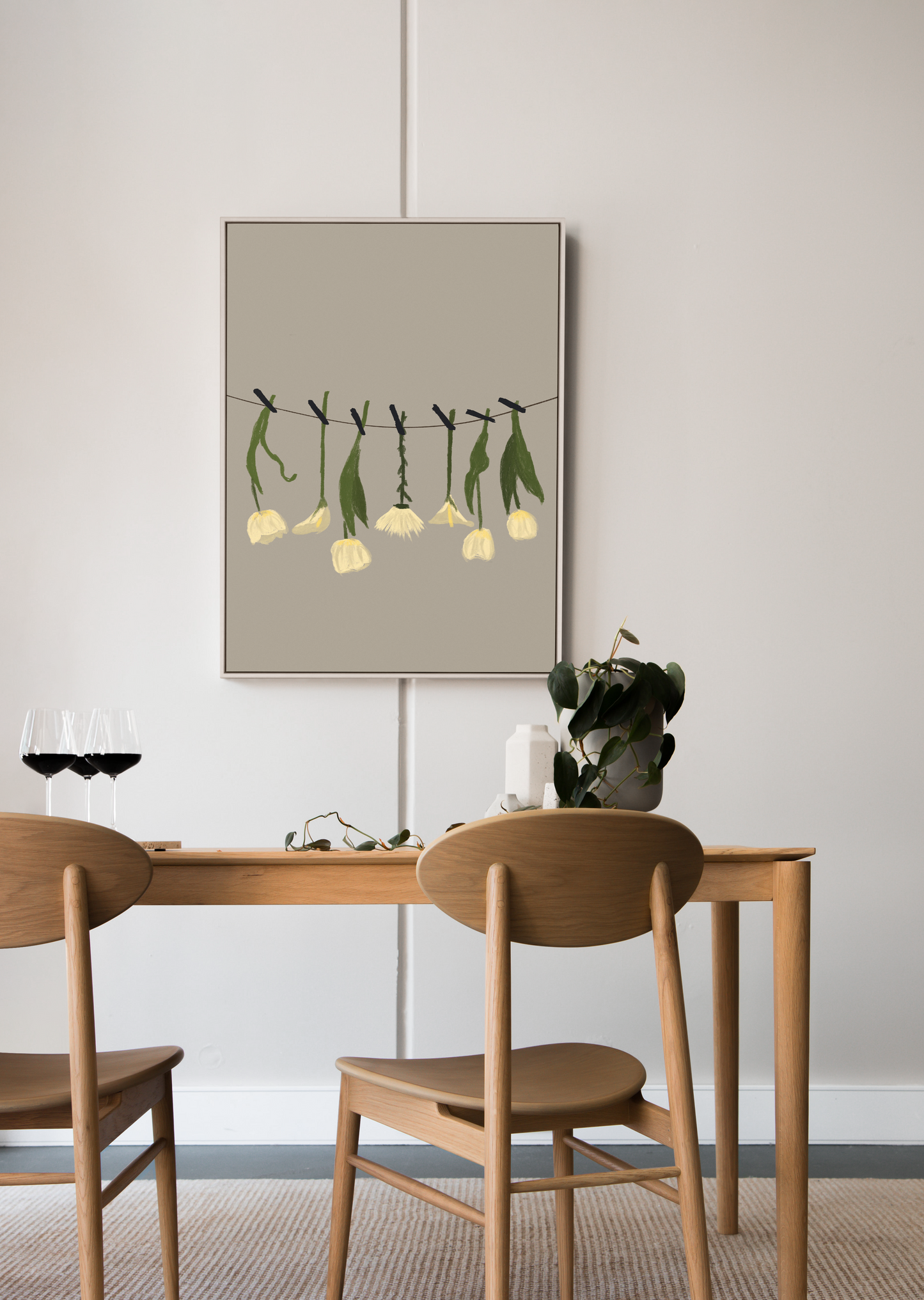 A contemporary digital painting of white blossoms strung up on a line, framed in a sleek wooden frame, accentuating a modern dining room with wine glasses on the table
